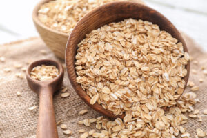 Bowl and plate with raw oatmeal on table